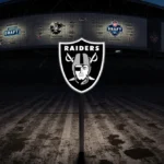 Las Vegas Raiders logo standing alone on dimly lit worn-out football field at dusk with stadium facade and NFL Draft draft gr