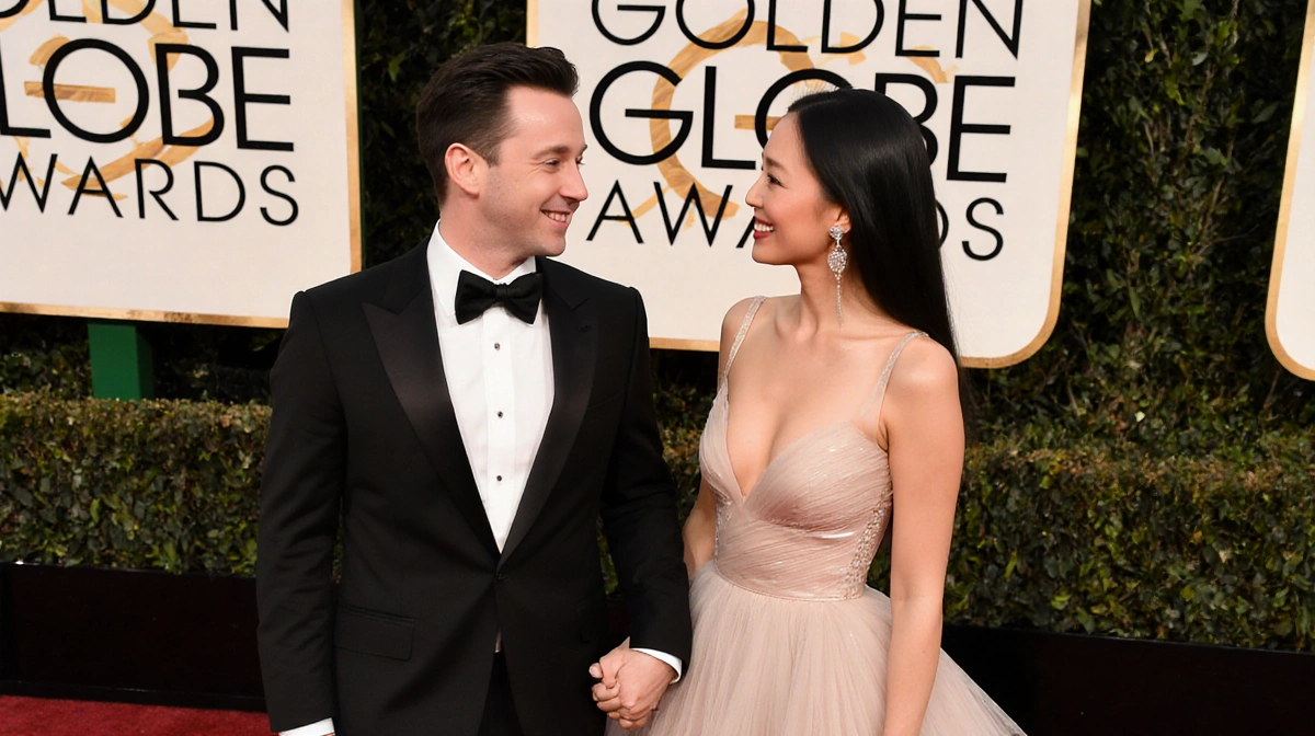 Macaulay Culkin and Brenda Song holding hands on red carpet with elegant gown and tuxedo showing Hollywood couple love