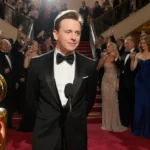 Macaulay Culkin accepting Golden Globe with trophy and red carpet crowd behind him