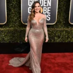 Melissa McCarthy walking the Golden Globes red carpet with sparkling gown and sleek ponytail
