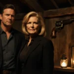 Michelle Pfeiffer stands with Kurt Russell in a lantern-lit barn with family revolver resting behind them