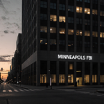 Silhouette of Renee Good walking away with the FBI building looming and dim Minneapolis streets in background.