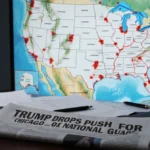 Newspaper headline Trump drops push for National Guard sits on desk with papers and lit map of the United States
