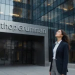 Professional woman stands confidently near Northrop Grumman headquarters with blue silver logo showing innovation