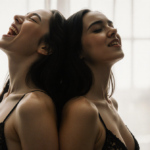 Two women pose with arms over each other