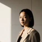 Petite woman wearing tailored jacket with fitted shoulders and soft side lighting showing confident style