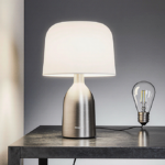Philips Hue Signe smart lamp rests on a metal desk with a brushed-metal base and visible heat-sink fins and LED bulbs