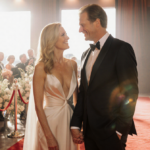 Helen Hunt and Jeffrey Nordling hold hands on a red carpet with warm lighting and subtle floral accents