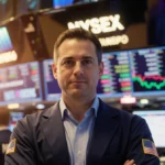 CEO Richard Ricci stands confidently before trading floor screens with golden lighting and financial data flowing