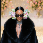 Rihanna walking out of Paris Fashion Week with a fur stole and flower earmuffs glowing in golden light