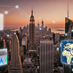 Screens display Ripple logo and cryptocurrency charts with skyline and sunset lighting in financial district