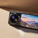 Futuristic smartphone sits atop a desk with golden light and a vibrant landscape on its screen