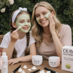 Sarah Michelle Gellar and daughter Charlotte apply facial masks with candles and Olay Regenerist cream on a wooden table.