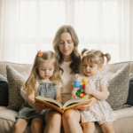 Sarah Rafferty hugs her daughters with a warm family portrait in a cozy living room