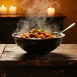 Steamy bowl of Louisiana gumbo rests on rustic wood table with flickering candles behind and spoon ready for serving