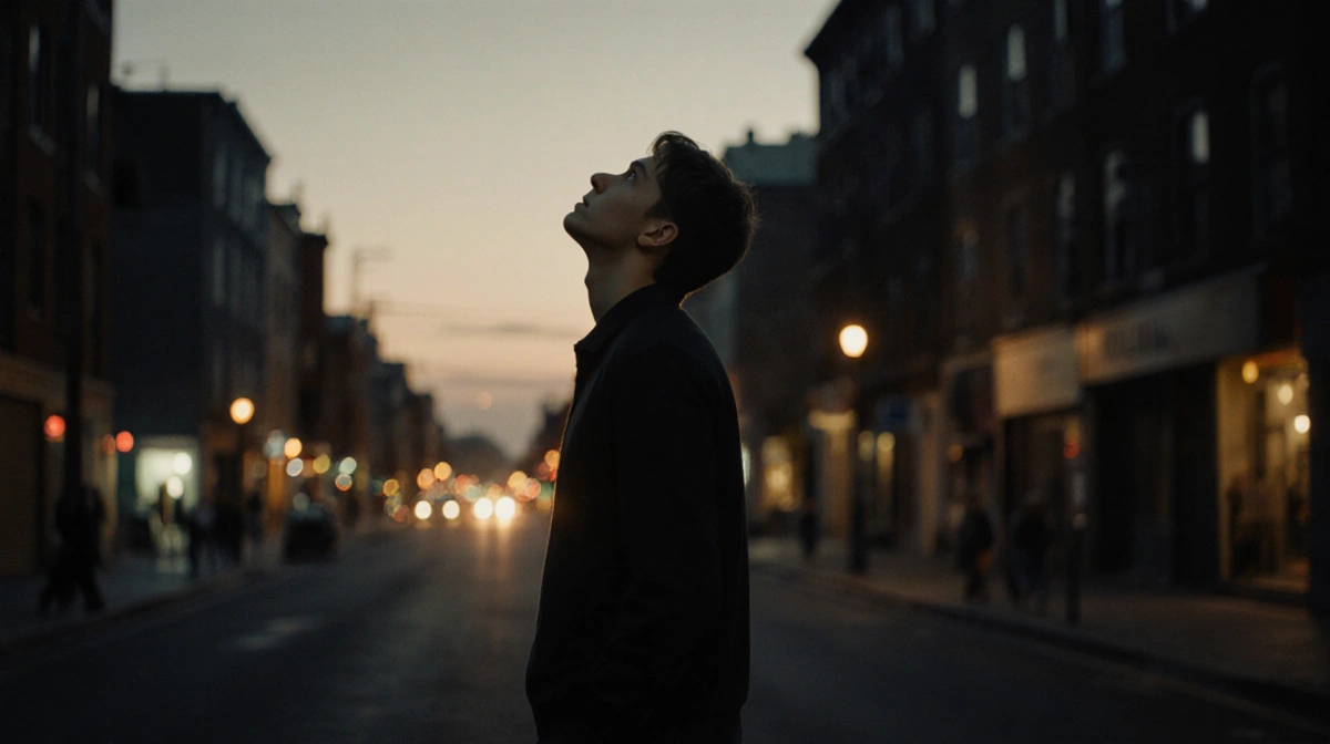 Stephen Graham walking alone down dim street with warm city lights and contemplative expression