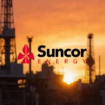 Suncor Energy logo stands bold against golden sunset with industrial equipment and oil rig in background