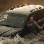 Two bystanders lifting a sinking SUV with a trapped driver golden light highlighting the heroic rescue.