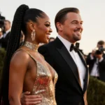 Teyana Taylor and Leonardo DiCaprio chatting on the Golden Globes red carpet with glamorous outfits and excited fans behind t