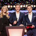 Three Season 29 Voice coaches standing together holding a microphone and tablet with stage lights and confetti in background