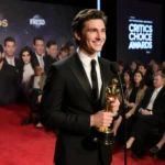 Timothée Chalamet speaking with Critics Choice Award and Kylie Jenner holding his hand under golden lighting.