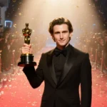 Timothée Chalamet holds Golden Globe award with red carpet and confetti behind him