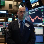 Trader watching crashing Dow Jones numbers with glowing screens showing market data