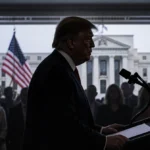 Trump stands at podium with worried faces and American flag behind him