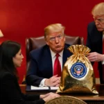Trump accepting gift bag behind desk with Nobel Prize and opposition leader showing shock