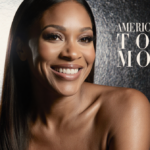 Tyra Banks sits front of metallic backdrop with cityscape reflection and warm glow.