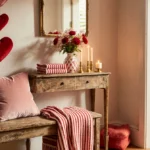 Cozy living room entrance shows pink velvet pillow on distressed bench with Valentine