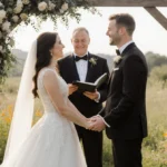 Vanna White and John Donaldson kissing at outdoor wedding ceremony with wildflowers and wooden arch